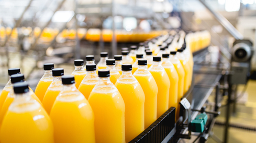 Bottling factory - Orange juice bottling line for processing and bottling juice into bottles. Selective focus.